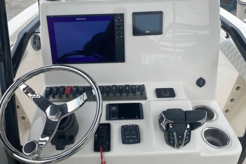 Slide: The Image of Control panel of 2026 Sea Chaser 24 HFC boat with steering wheel and electronic displays. - 6