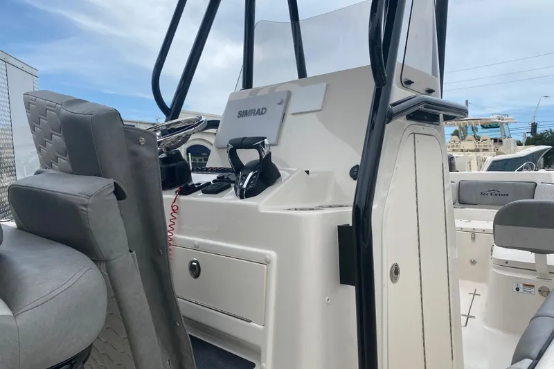 Slide: The Image of 2026 Sea Chaser 24 HFC boat interior with steering console and seating. - 8