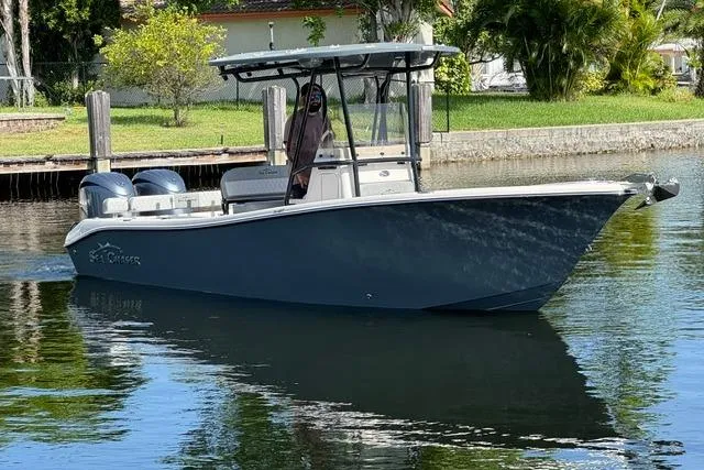 Slide: The Image of 2026 Sea Chaser 24 HFC boat on calm water near a dock, surrounded by greenery. - 6