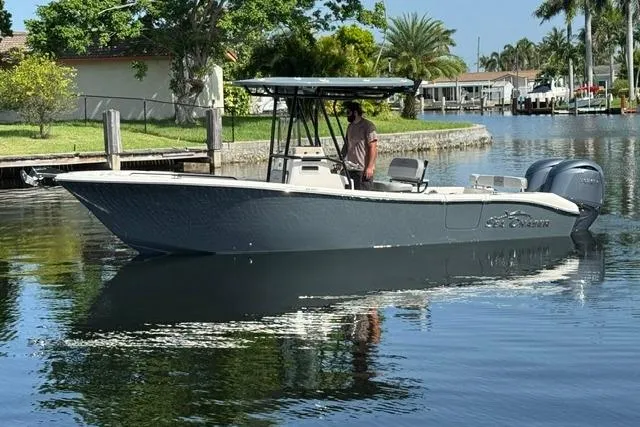 Slide: The Image of 2026 Sea Chaser 24 HFC boat cruising on a calm canal with lush greenery. - 2