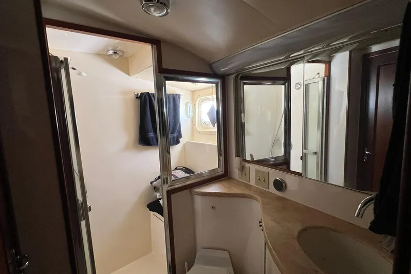 Slide: The Image of Bathroom interior of 1990 Hatteras 41 Convertible yacht, featuring sink, mirror, and shower. - 15