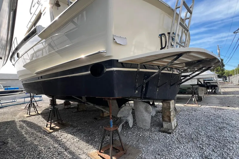 Slide: The Image of 1990 Hatteras 41 Convertible boat on stands, showcasing hull and propellers. - 3