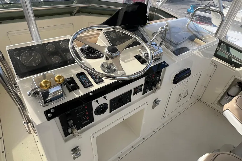 Slide: The Image of 1990 Hatteras 41 Convertible yacht helm with steering wheel and control panel. - 4