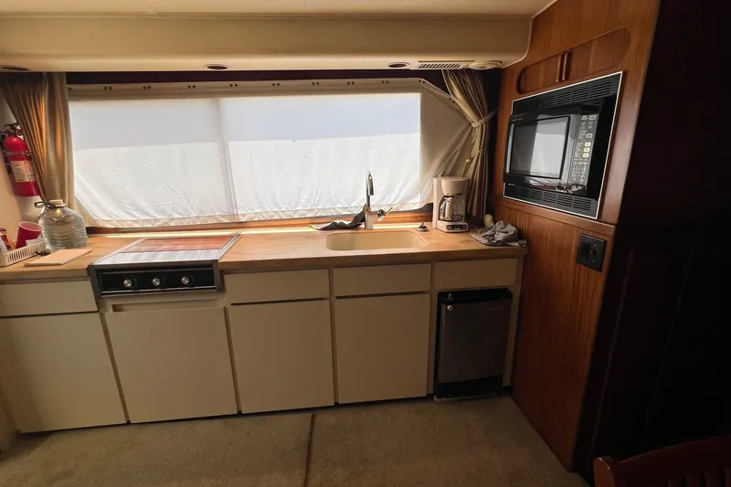 Slide: The Image of Interior kitchen of 1990 Hatteras 41 Convertible yacht with appliances and window view. - 36
