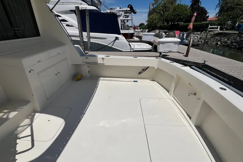 Slide: The Image of Spacious deck of a 1990 Hatteras 41 Convertible yacht docked at a marina. - 35