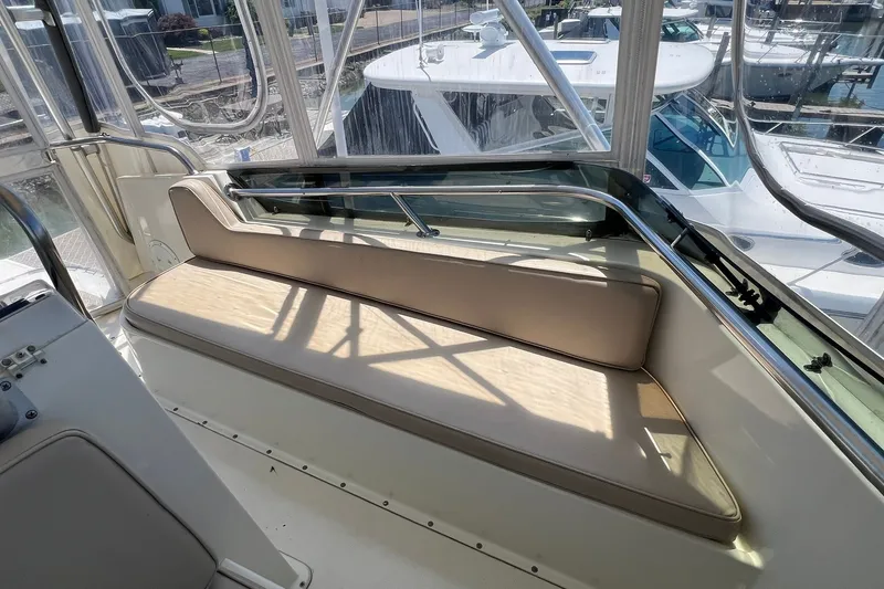 Slide: The Image of Interior seating area of a 1990 Hatteras 41 Convertible yacht, featuring beige cushions. - 3