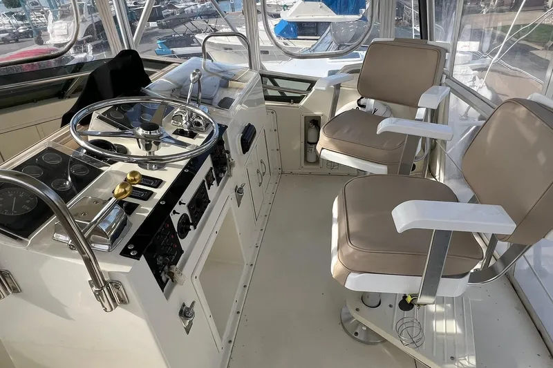 Slide: The Image of Cockpit of 1990 Hatteras 41 Convertible yacht with dual helm chairs and control panel. - 5