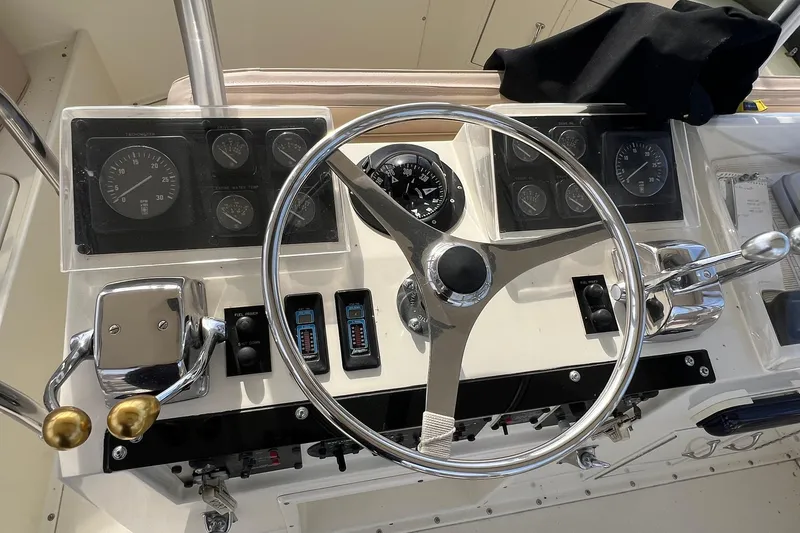 Slide: The Image of Control panel of a 1990 Hatteras 41 Convertible boat with steering wheel and gauges. - 7