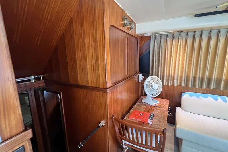 Slide: The Image of Interior of 1990 Hatteras 41 Convertible yacht with wood paneling, table, fan, and sofa. - 15