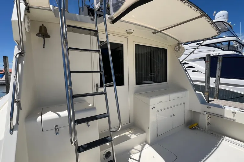 Slide: The Image of 1990 Hatteras 41 Convertible yacht deck with ladder and storage compartments. - 12