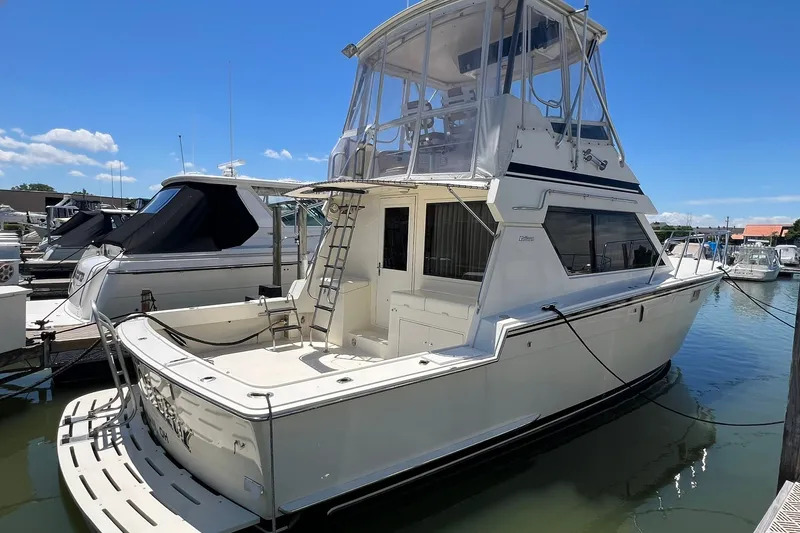 The Image of 1990 Hatteras 41 Convertible yacht docked at marina under clear blue sky. - 0