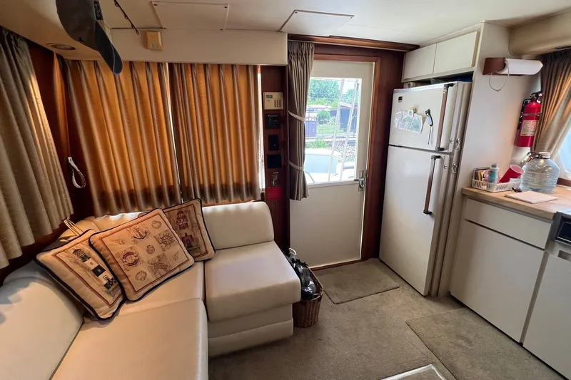 Slide: The Image of Interior of a 1990 Hatteras 41 Convertible yacht with cozy seating and kitchen area. - 25