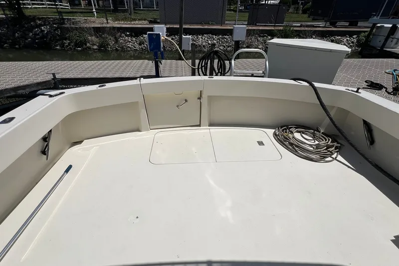 Slide: The Image of 1990 Hatteras 41 Convertible boat deck with coiled rope and dockside view. - 34