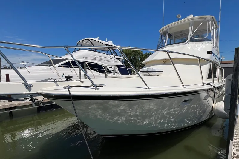 The Image of 1990 Hatteras 41 Convertible yacht docked in marina under clear blue sky. - 0