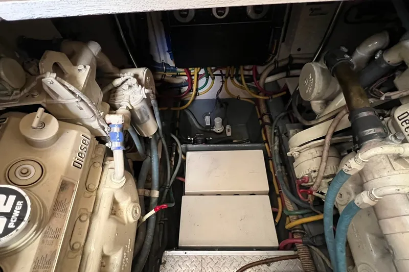Slide: The Image of Engine room of a 1990 Hatteras 41 Convertible boat, showcasing diesel engines and wiring. - 30