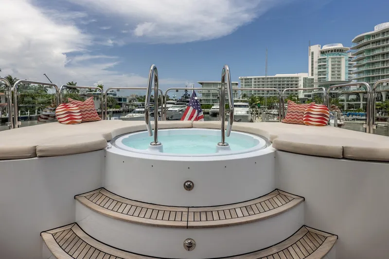 Slide: The Image of Luxurious Trinity Yachts 1998 model with jacuzzi, docked at marina, featuring plush seating and scenic views. - 54