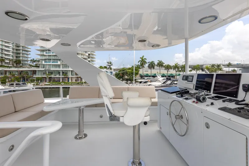 Slide: The Image of Luxurious 1998 Trinity Yachts helm with modern controls and seating, docked near waterfront buildings. - 56