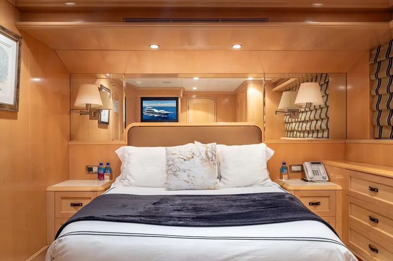 Slide: The Image of Luxurious bedroom interior on a 1998 Trinity Yachts model, featuring elegant wood paneling and plush bedding. - 32