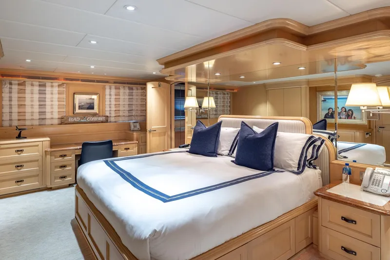 Slide: The Image of Luxurious bedroom interior on 1998 Trinity Yachts, featuring elegant wood furnishings and plush bedding. - 25
