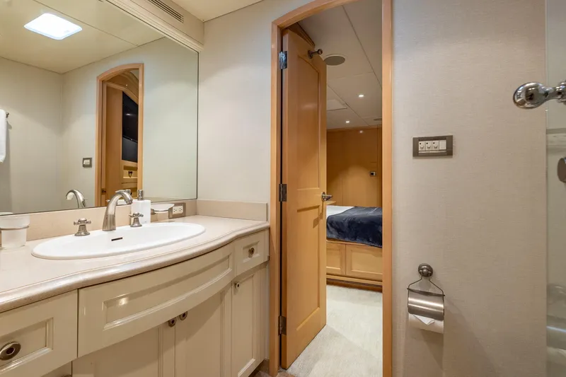 Slide: The Image of Luxurious yacht bathroom with modern fixtures, mirror, and open door to bedroom, Trinity Yachts 1998. - 46