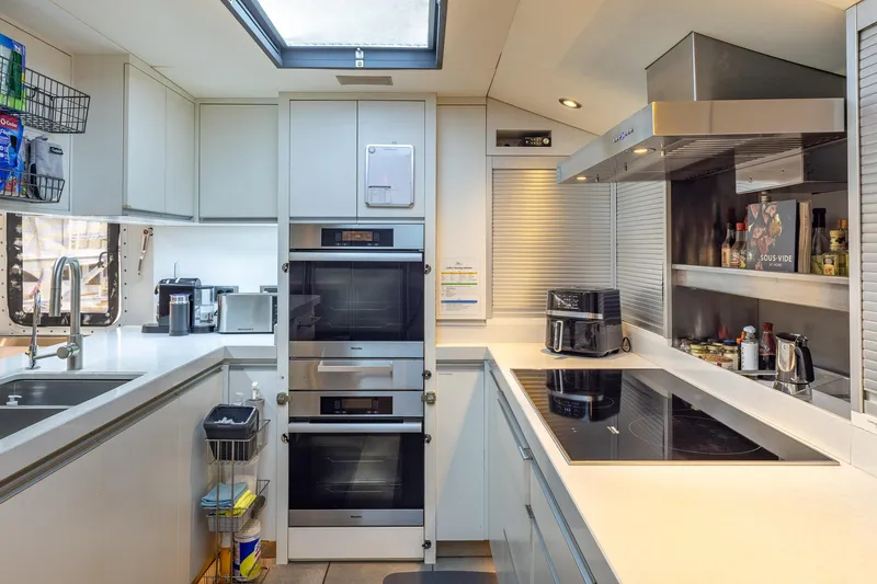 Slide: The Image of Modern yacht kitchen with sleek appliances, ample counter space, and natural light from skylight. - 21