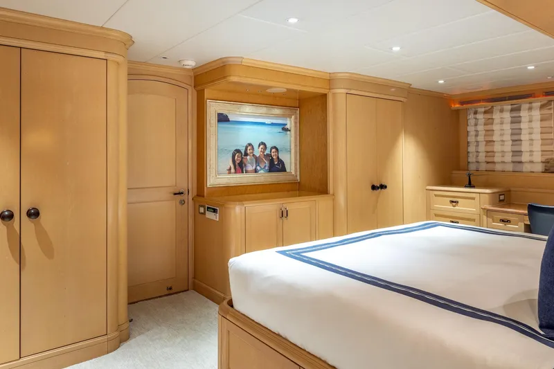 Slide: The Image of Luxurious 1998 Trinity Yachts cabin with elegant wood paneling and cozy bedding. - 26