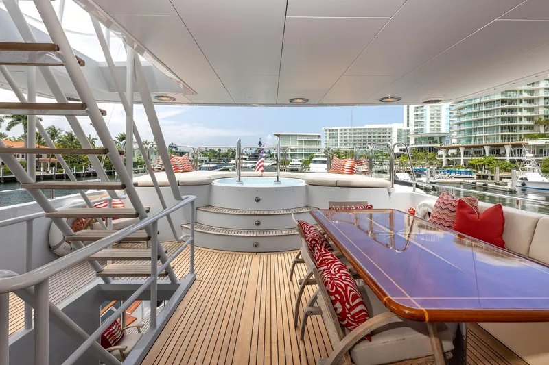 Slide: The Image of Luxurious 1998 Trinity Yachts deck with elegant seating, wooden table, and scenic marina view. - 53