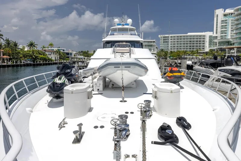 Slide: The Image of Luxurious 1998 Trinity Yachts model docked, featuring jet skis and lifeboat on deck. - 22