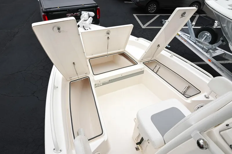 Slide: The Image of 2021 Pathfinder 2200 TRS boat with open storage compartments, parked in a lot. - 50