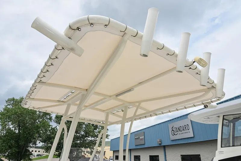 Slide: The Image of T-top of 2021 Pathfinder 2200 TRS boat with rod holders, against cloudy sky. - 37