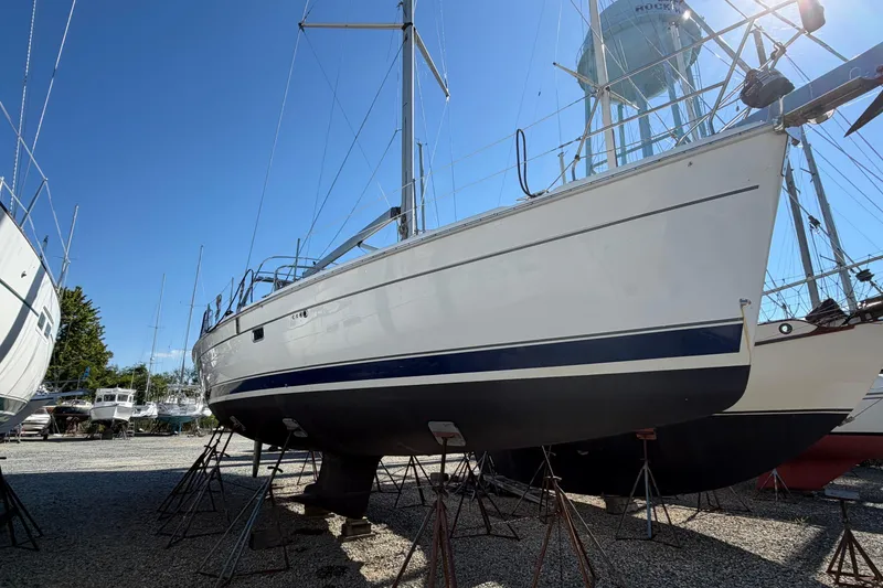 Slide: The Image of 2007 Hunter 45 Center Cockpit sailboat on stands in a boatyard under clear blue sky. - 1