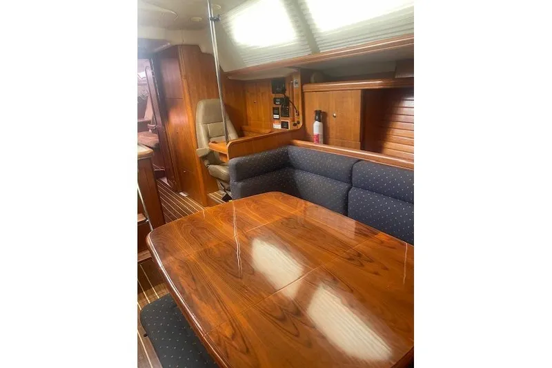 Slide: The Image of Interior of 2007 Hunter 45 Center Cockpit yacht with polished wood table and seating. - 10