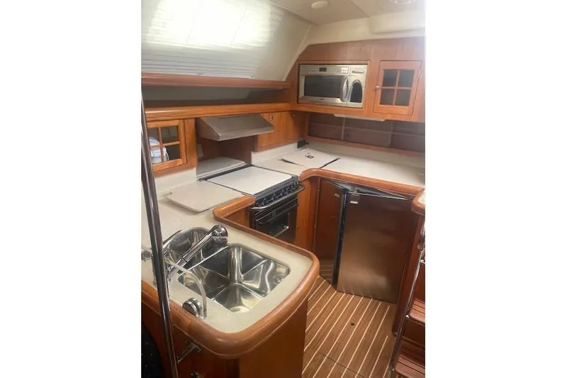 Slide: The Image of Luxurious 2007 Hunter 45 Center Cockpit yacht kitchen with modern appliances and wood finish. - 11