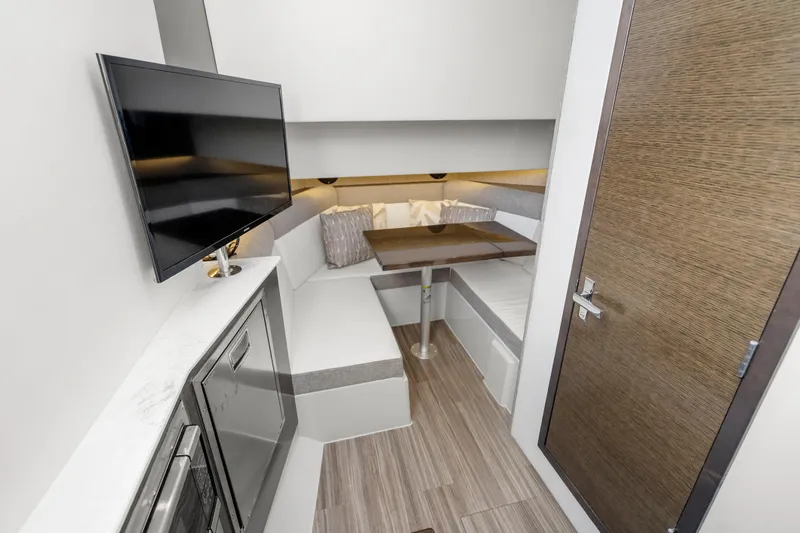 Slide: The Image of Interior of 2020 Cruisers Yachts 38 GLS OB, featuring a cozy seating area and TV. - 17