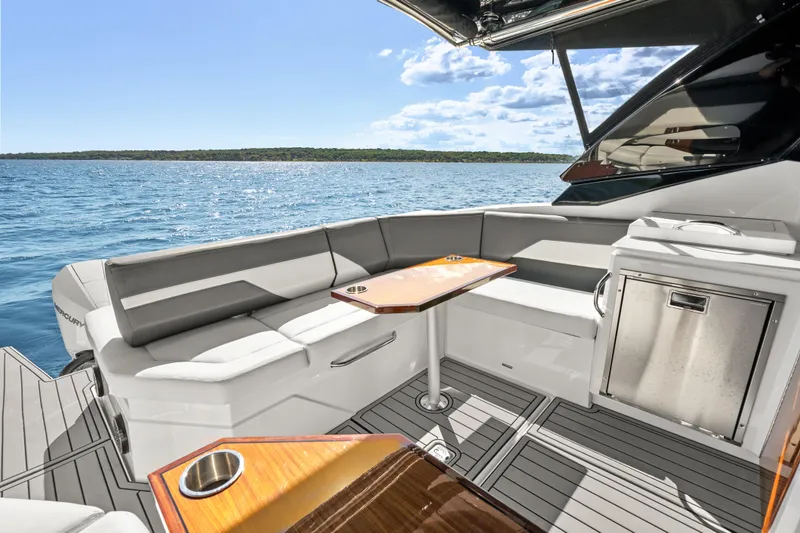 Slide: The Image of Luxurious 2020 Cruisers Yachts 38 GLS OB interior with seating and table, overlooking serene waters. - 14