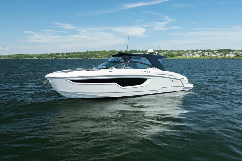 The Image of 2020 Cruisers Yachts 38 GLS OB on a serene lake under a clear blue sky. - 0