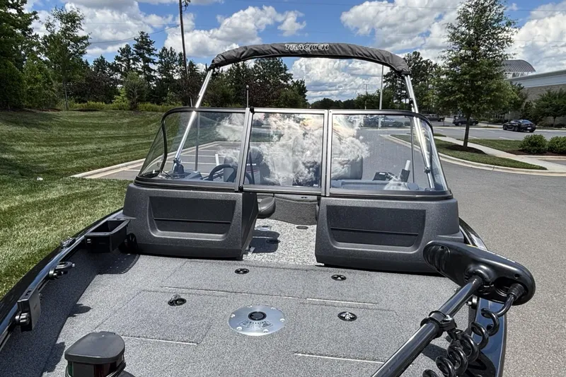 Slide: The Image of 2025 Tracker Pro Guide V-16 WT boat on pavement, surrounded by greenery and blue sky. - 10