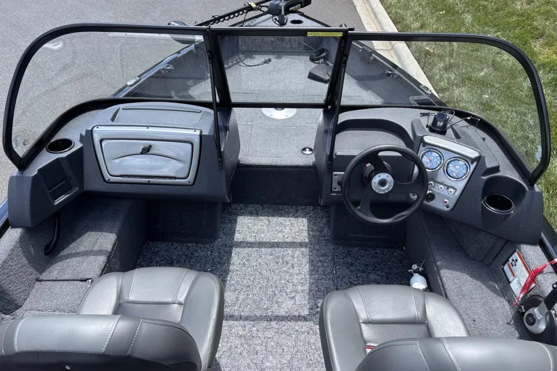 Slide: The Image of 2025 Tracker Pro Guide V-16 WT boat interior with steering wheel and seating. - 14