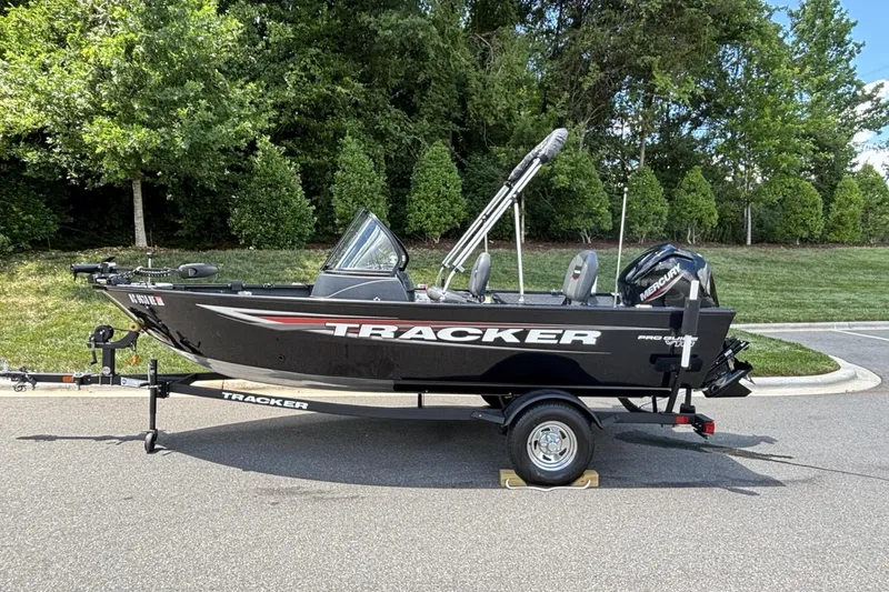 Slide: The Image of 2025 Tracker Pro Guide V-16 WT boat on trailer, parked outdoors. - 16