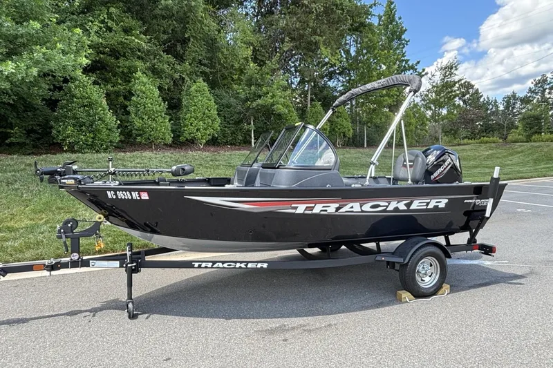 Slide: The Image of 2025 Tracker Pro Guide V-16 WT boat on trailer, parked outdoors. - 17