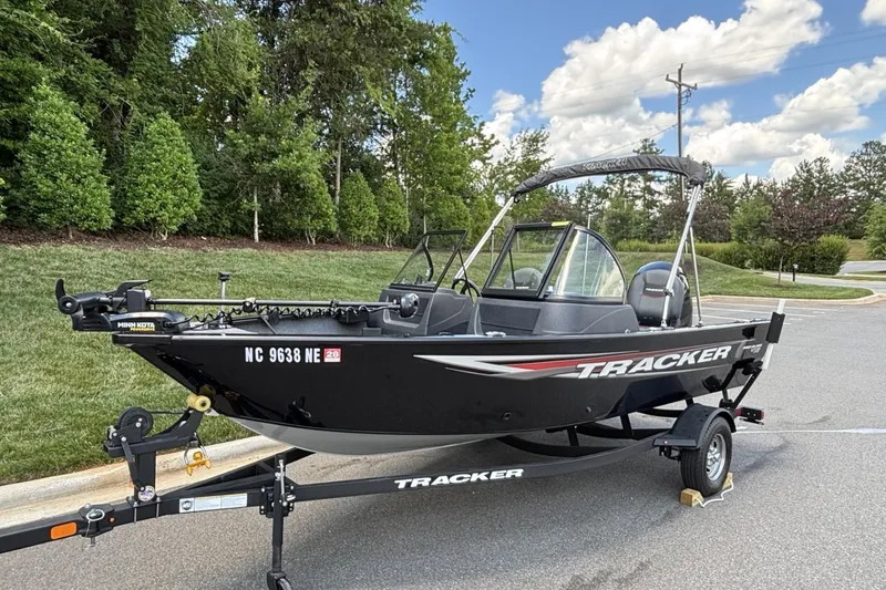 Slide: The Image of 2025 Tracker Pro Guide V-16 WT boat on trailer, parked outdoors. - 18