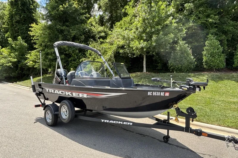 Slide: The Image of 2025 Tracker Pro Guide V-16 WT boat on trailer, parked on a sunny day. - 3