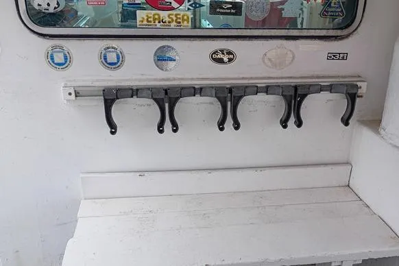 Slide: The Image of 1980 Thompson Passenger and Dive Trawler interior with hooks and various stickers on the wall. - 16