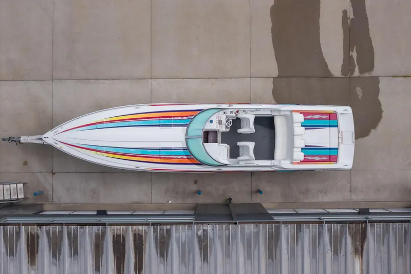 Slide: The Image of Overhead view of a 2002 Formula 382 FASTech boat with colorful stripes on concrete. - 18