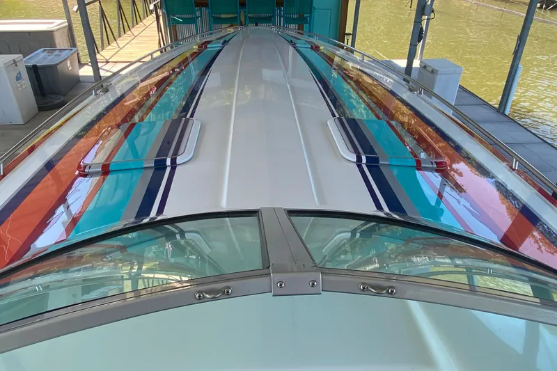 Slide: The Image of 2002 Formula 382 FASTech boat with colorful striped design docked by the water. - 28