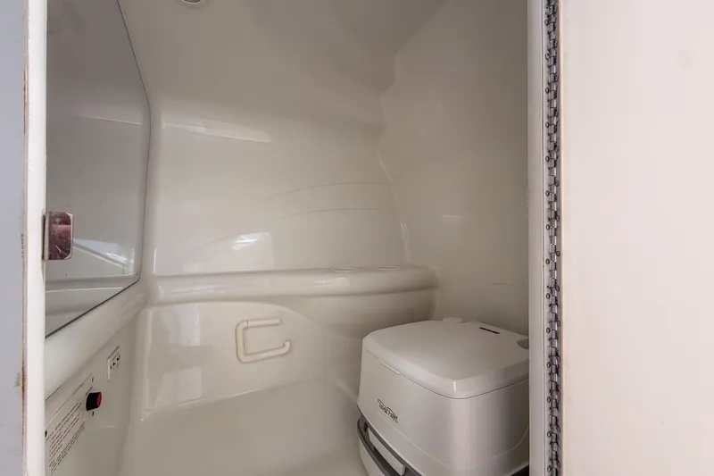 Slide: The Image of 2002 Formula 382 FASTech boat bathroom with compact toilet and white interior. - 9