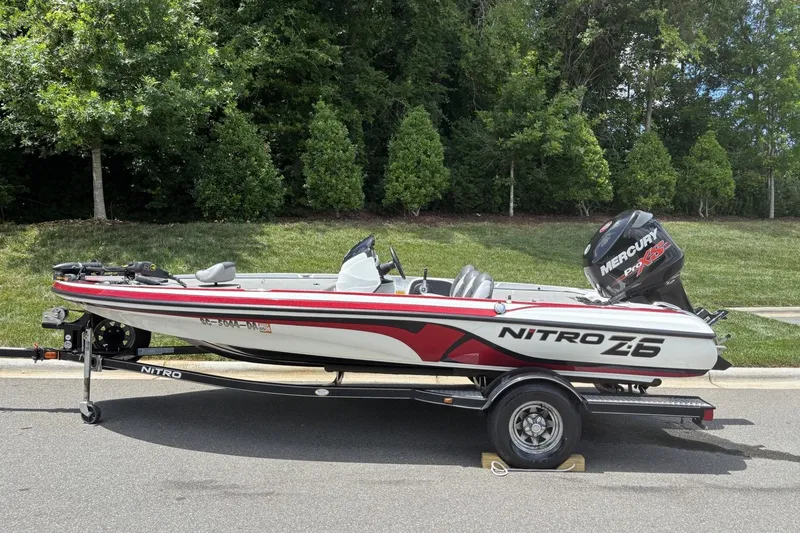 The Image of 2014 Nitro Z-6 boat with Mercury engine on a trailer, parked on a street. - 1