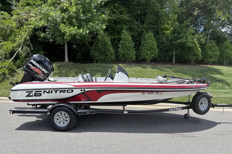 Slide: The Image of 2014 Nitro Z-6 boat with Mercury engine on trailer, parked on roadside. - 14