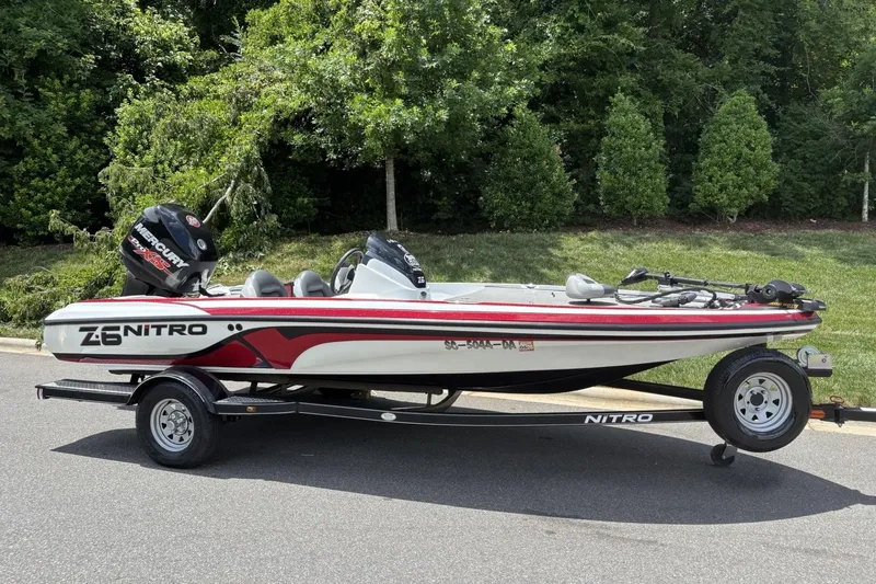 Slide: The Image of 2014 Nitro Z-6 boat on trailer, parked on road with lush greenery background. - 15