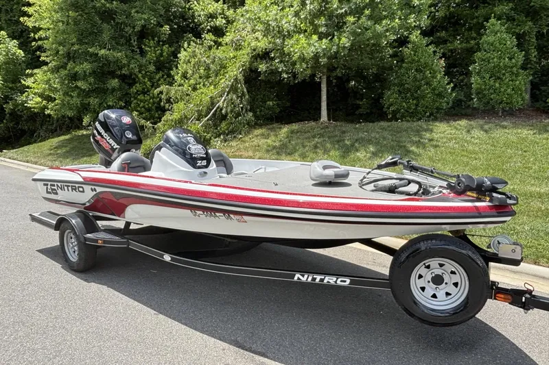 Slide: The Image of 2014 Nitro Z-6 boat on trailer, parked on a road with greenery background. - 16